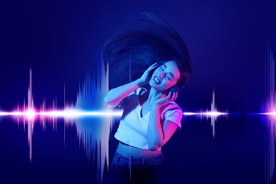 Image of Beautiful woman with headphones listening to music and dancing on dark blue background. Sound waves behind her