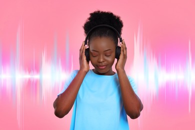 Young woman with headphones listening to music on pink background. Sound waves behind her