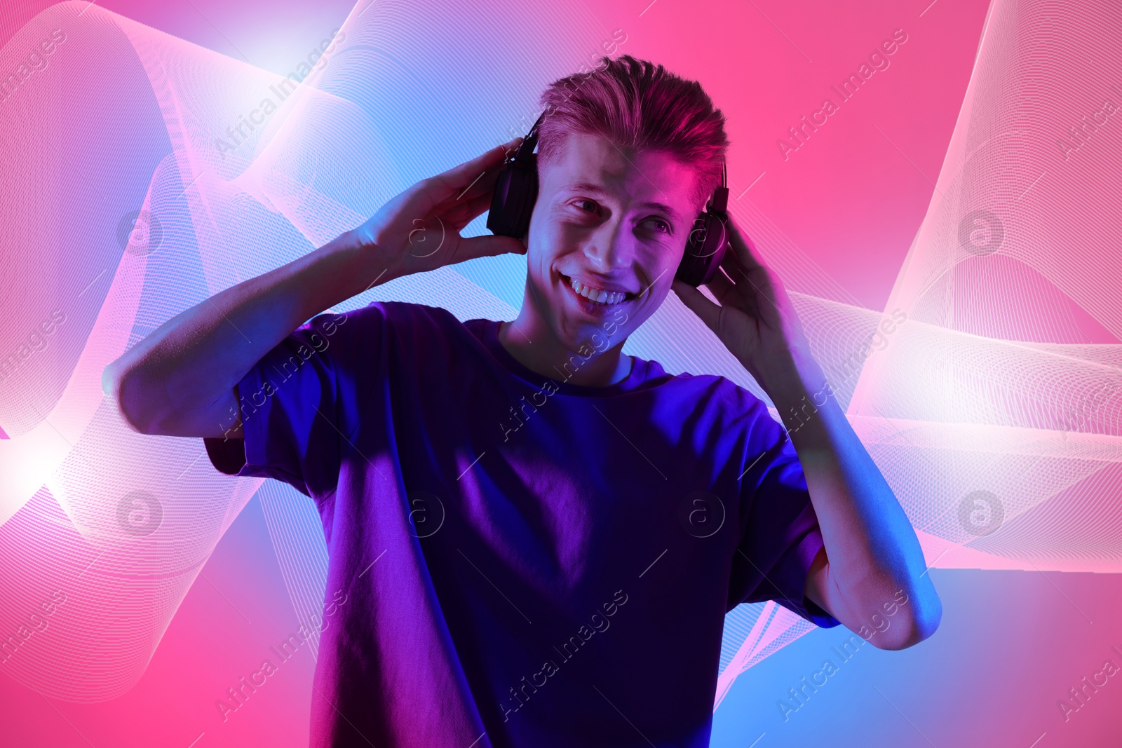 Image of Young man with headphones listening to music on color gradient background. Sound waves behind him