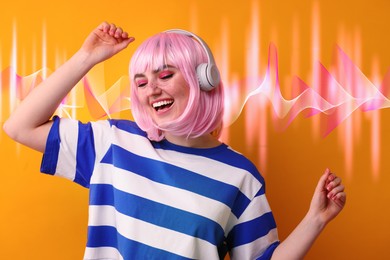 Image of Fashionable young woman in pink wig with headphones listening to music on orange background. Sound waves behind her