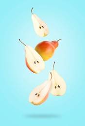 Fresh juicy pears in air on light blue background