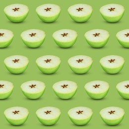 Image of Halves of fresh apple on light green background, seamless pattern