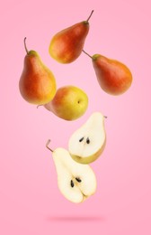 Fresh juicy pears in air on pink background