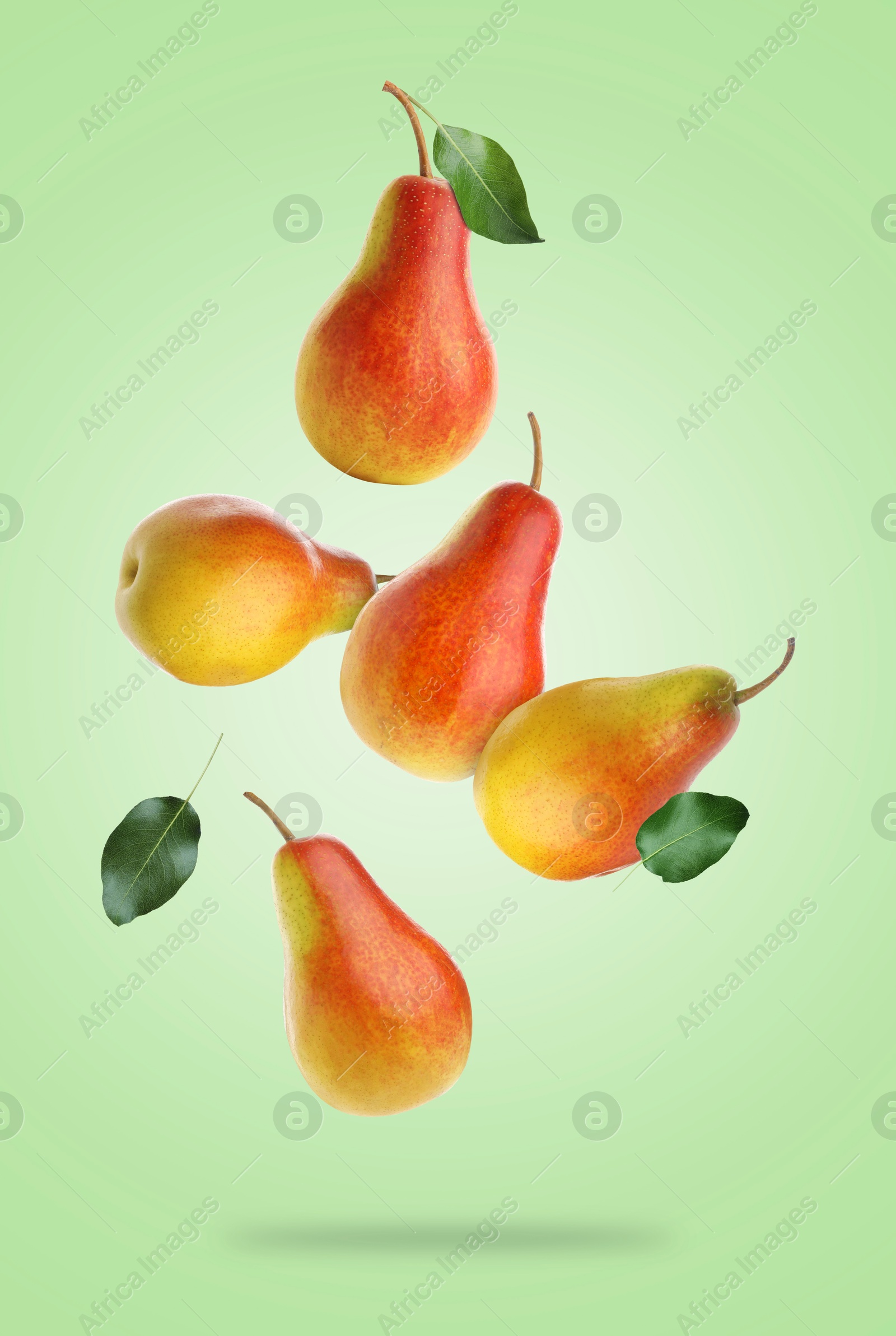 Image of Fresh juicy pears in air on light green background