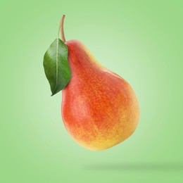 Image of Fresh juicy pear in air on light green background