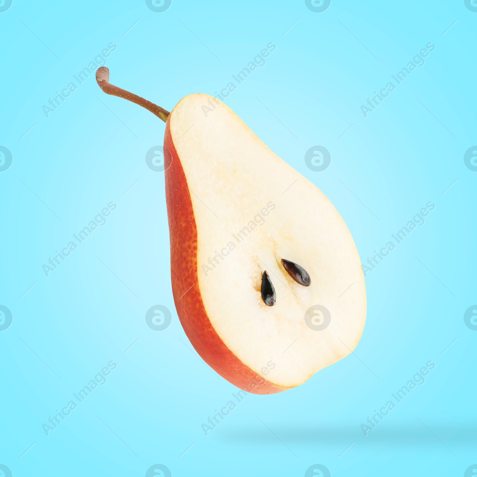 Image of Fresh sliced pear in air on light blue background