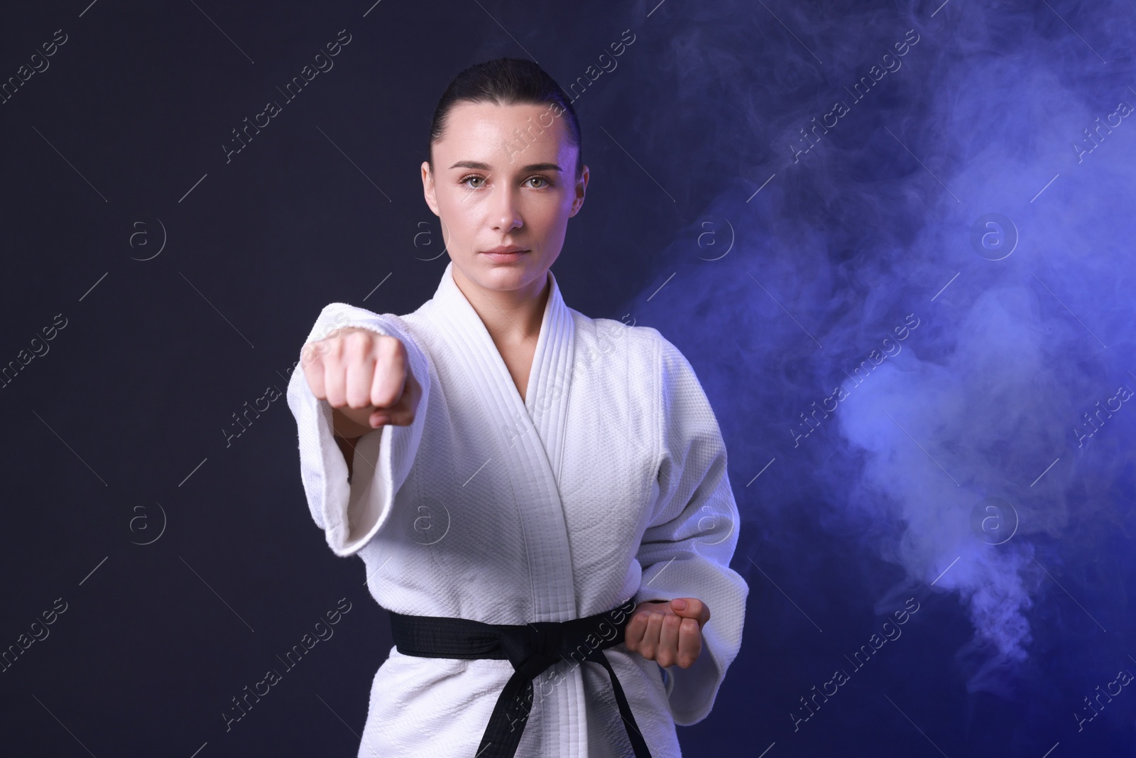 Photo of Karate fighter in kimono on dark blue background