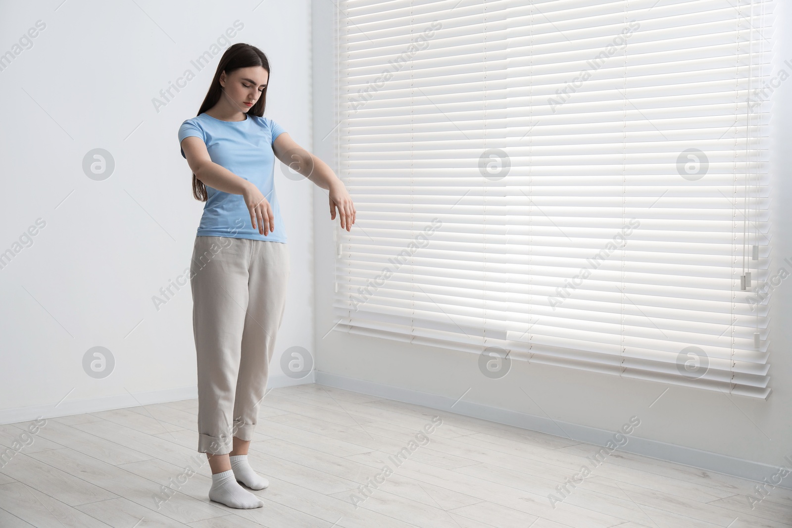 Photo of Young woman suffering from sleepwalking at home, space for text