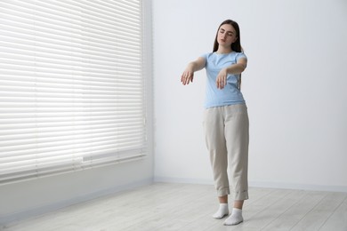 Photo of Young woman suffering from sleepwalking at home, space for text