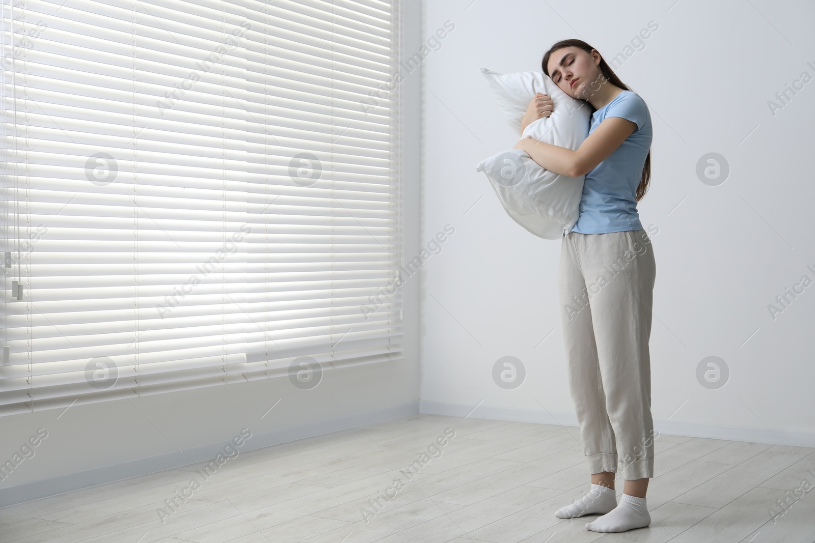 Photo of Young woman suffering from sleepwalking at home, space for text