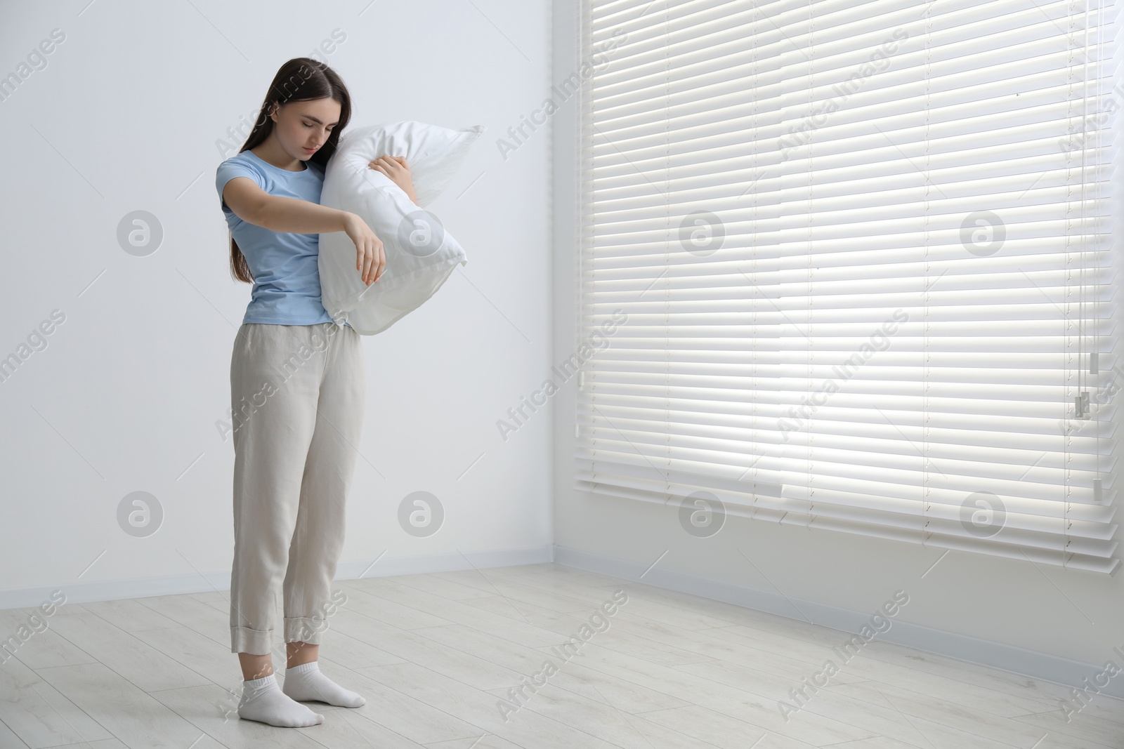 Photo of Young woman suffering from sleepwalking at home, space for text