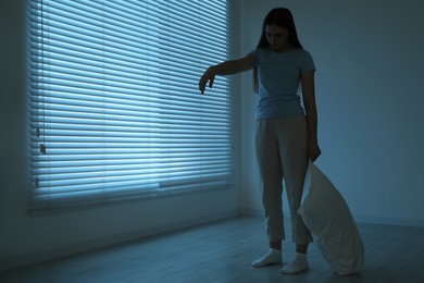 Photo of Young woman suffering from sleepwalking at home, space for text