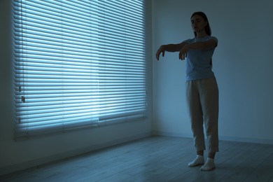 Photo of Young woman suffering from sleepwalking at home, space for text