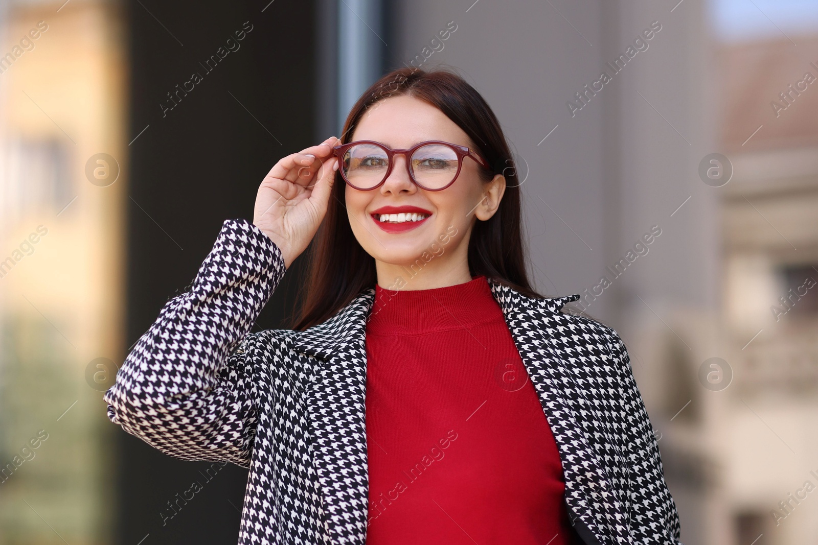 Photo of Portrait of smiling businesswoman in stylish suit outdoors