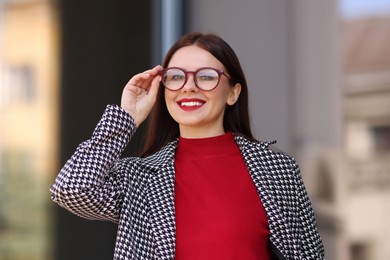 Photo of Portrait of smiling businesswoman in stylish suit outdoors