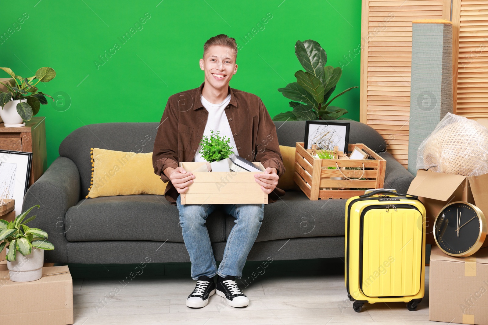 Photo of Happy man with different stuff in new apartment. Housewarming party