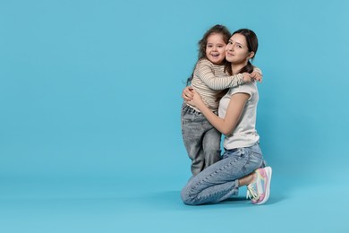 Photo of Portrait of cute sisters on light blue background, space for text