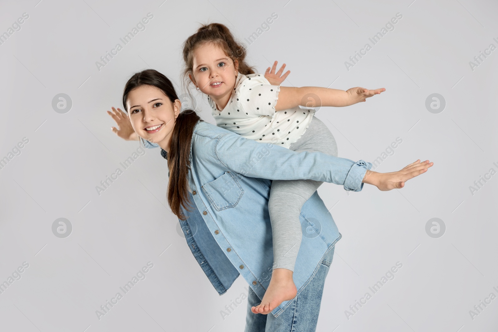 Photo of Portrait of cute sisters on white background