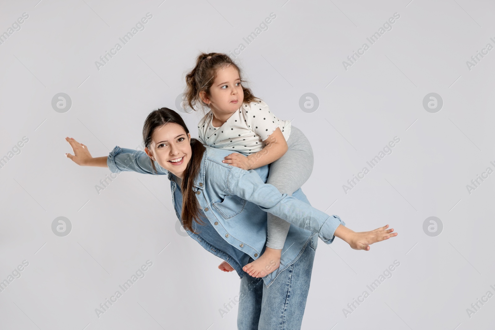 Photo of Portrait of cute sisters on white background