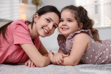 Photo of Portrait of cute little girl and her sister indoors