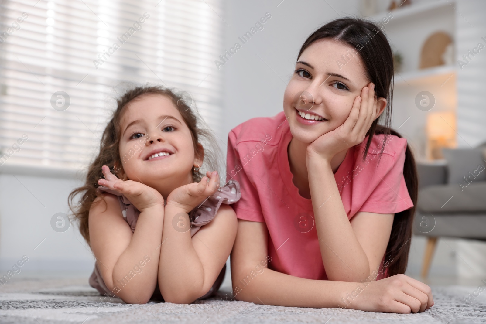 Photo of Portrait of cute little girl and her sister indoors