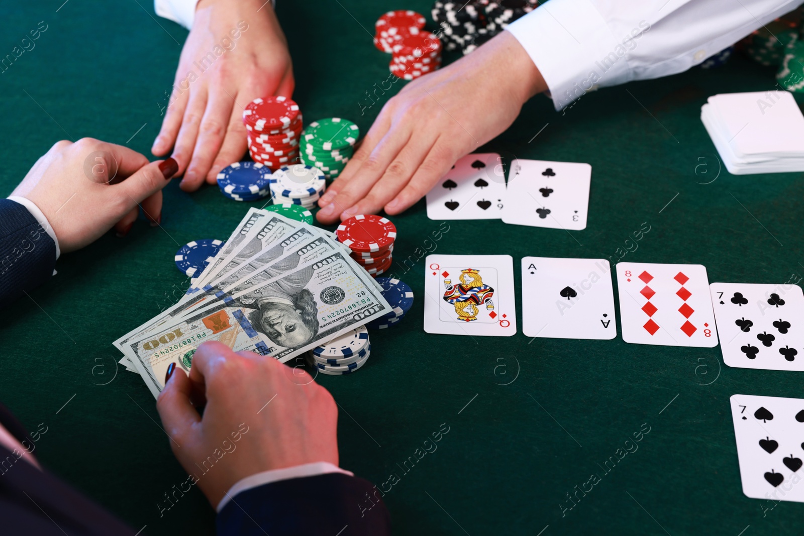 Photo of Gambler making bet with professional croupier at gambling table, closeup