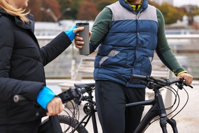 Photo of Couple with bicycles spending time together outdoors, closeup