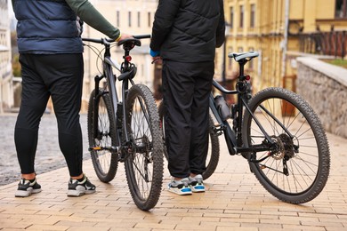 Photo of Couple with bicycles spending time together outdoors, closeup