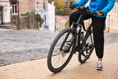 Photo of Woman with bicycle outdoors, closeup. Space for text