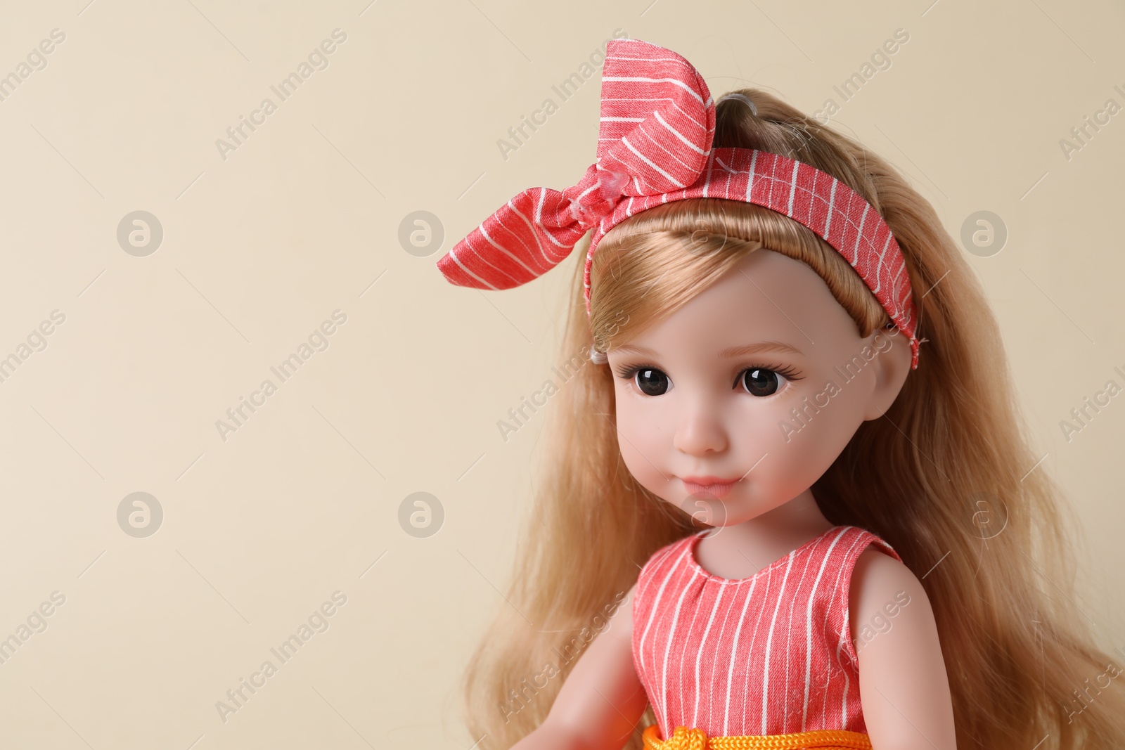 Photo of Beautiful doll with headband on beige background, closeup. Space for text