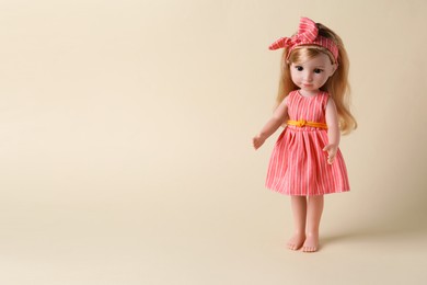 Photo of Beautiful doll in dress and headband on beige background. Space for text