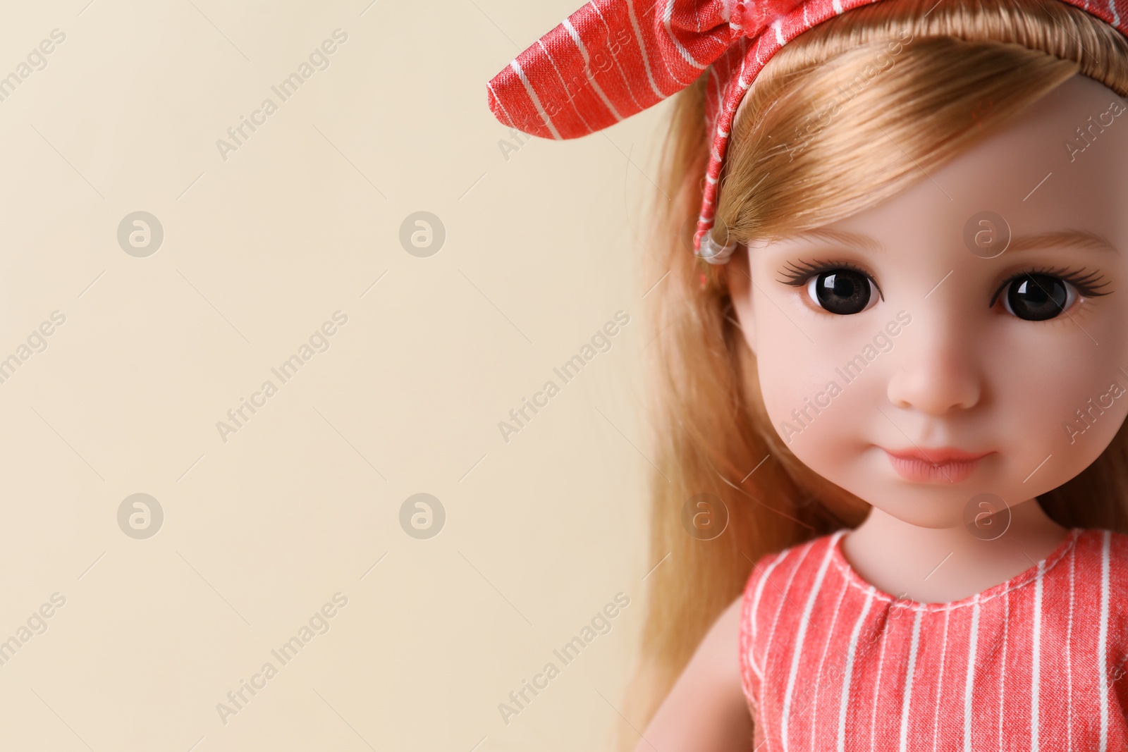 Photo of Beautiful doll with headband on beige background, closeup. Space for text