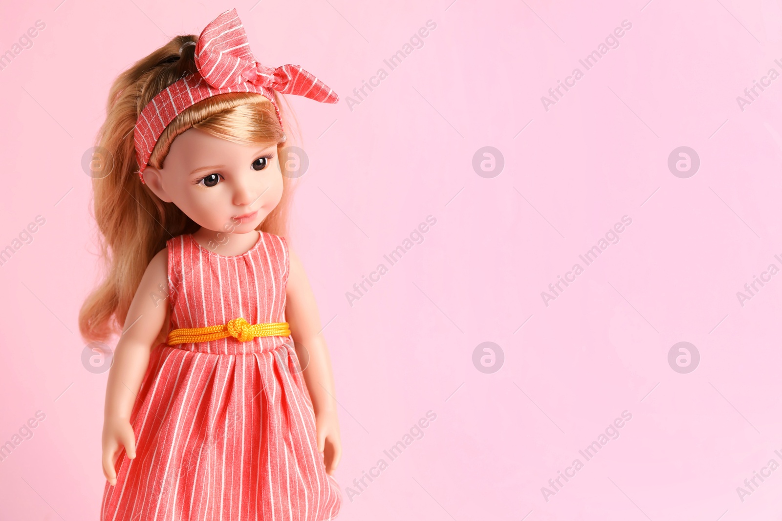 Photo of Beautiful doll in dress and headband on pink background. Space for text