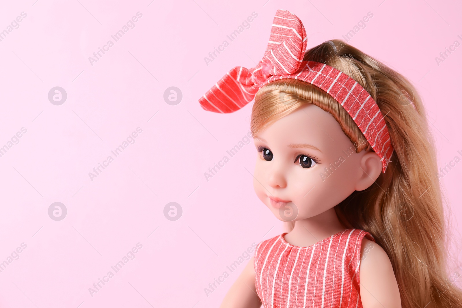 Photo of Beautiful doll with headband on pink background, closeup. Space for text