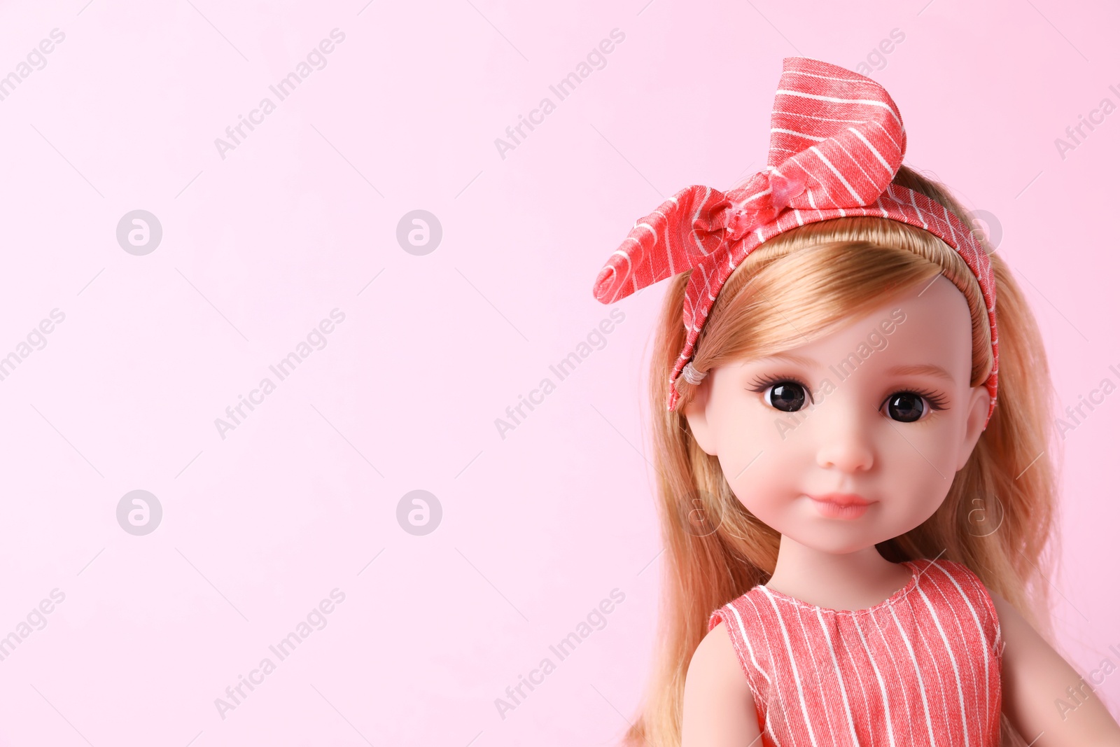 Photo of Beautiful doll with headband on pink background, closeup. Space for text