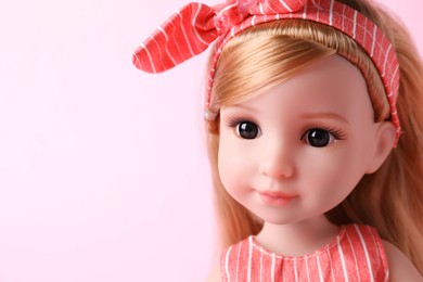 Photo of Beautiful doll with headband on pink background, closeup. Space for text