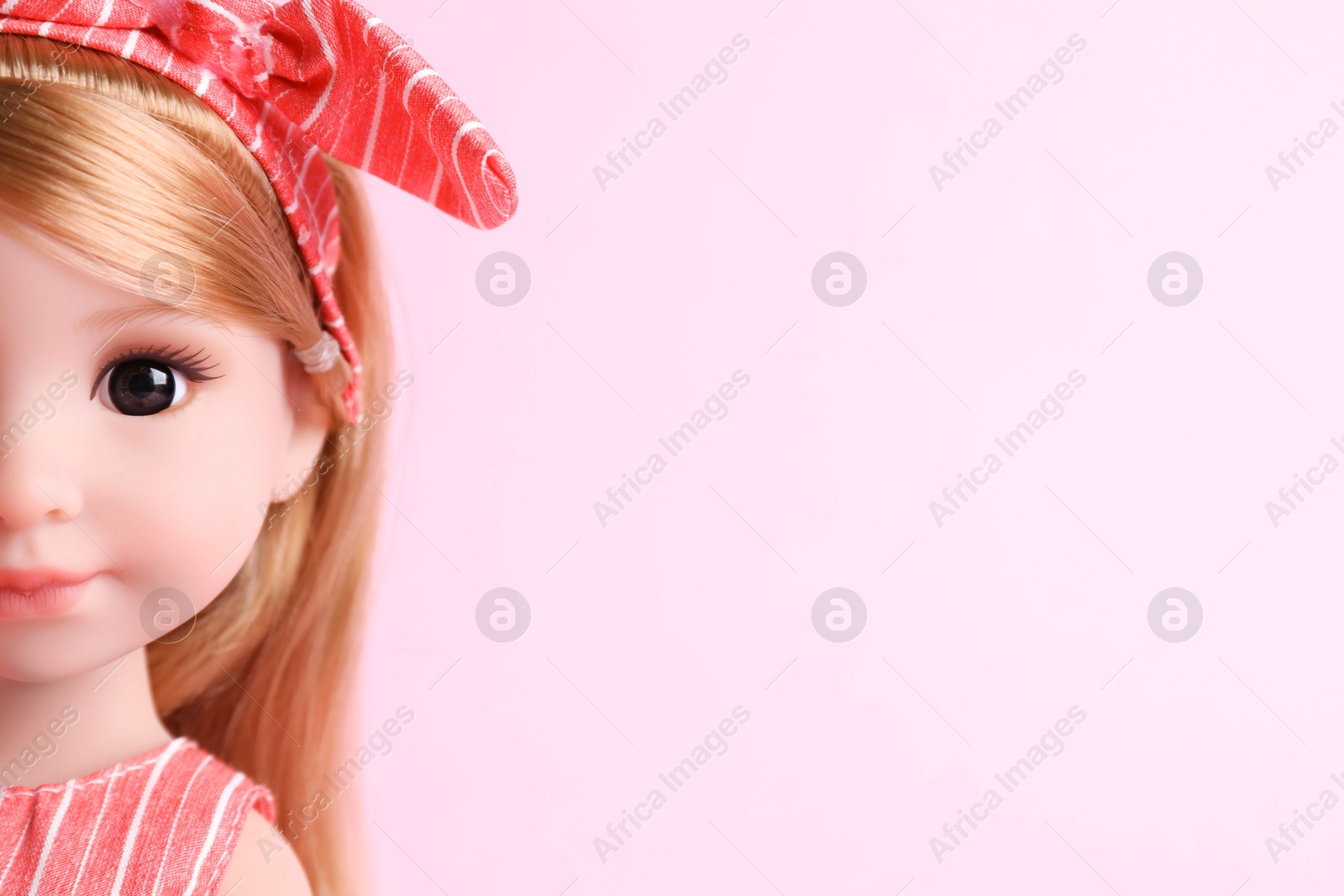 Photo of Beautiful doll with headband on pink background, closeup. Space for text