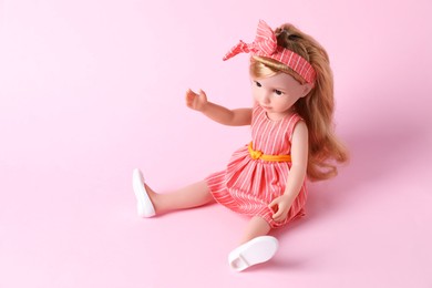 Photo of Beautiful doll in dress and headband on pink background