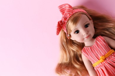 Photo of Beautiful doll in dress and headband on pink background, top view. Space for text