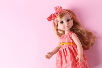 Photo of Beautiful doll in dress and headband on pink background, top view. Space for text