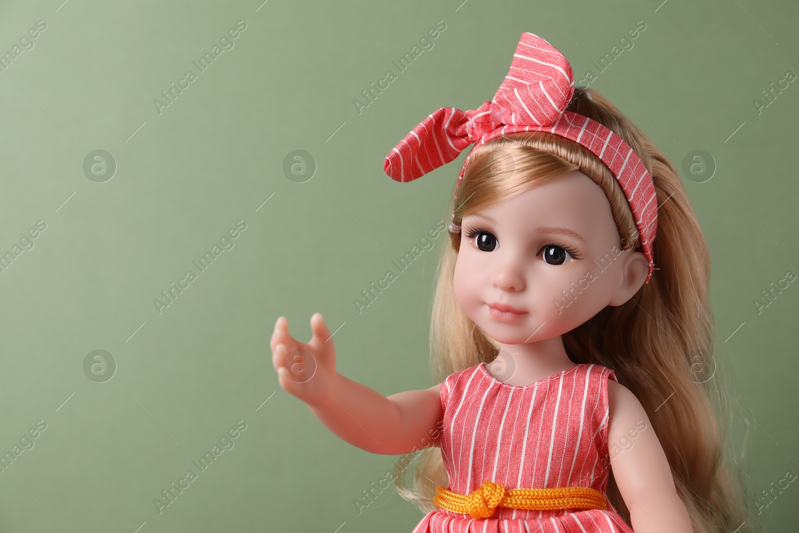 Photo of Beautiful doll in dress and headband on light green background, closeup. Space for text