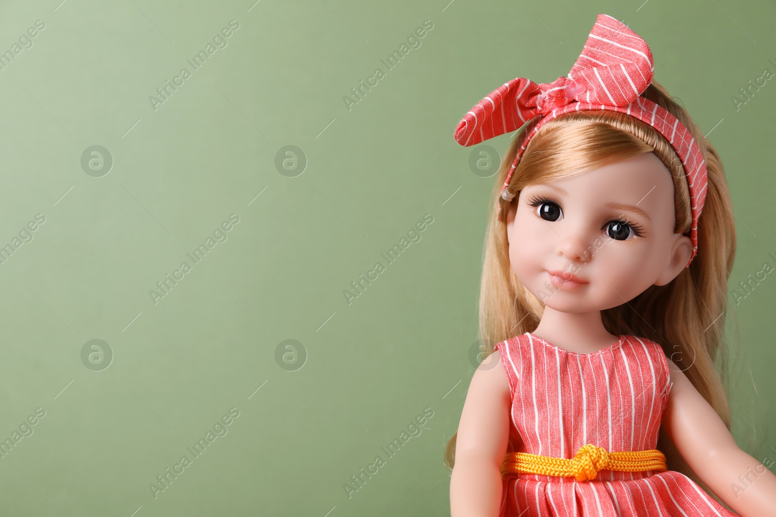 Photo of Beautiful doll in dress and headband on light green background, closeup. Space for text