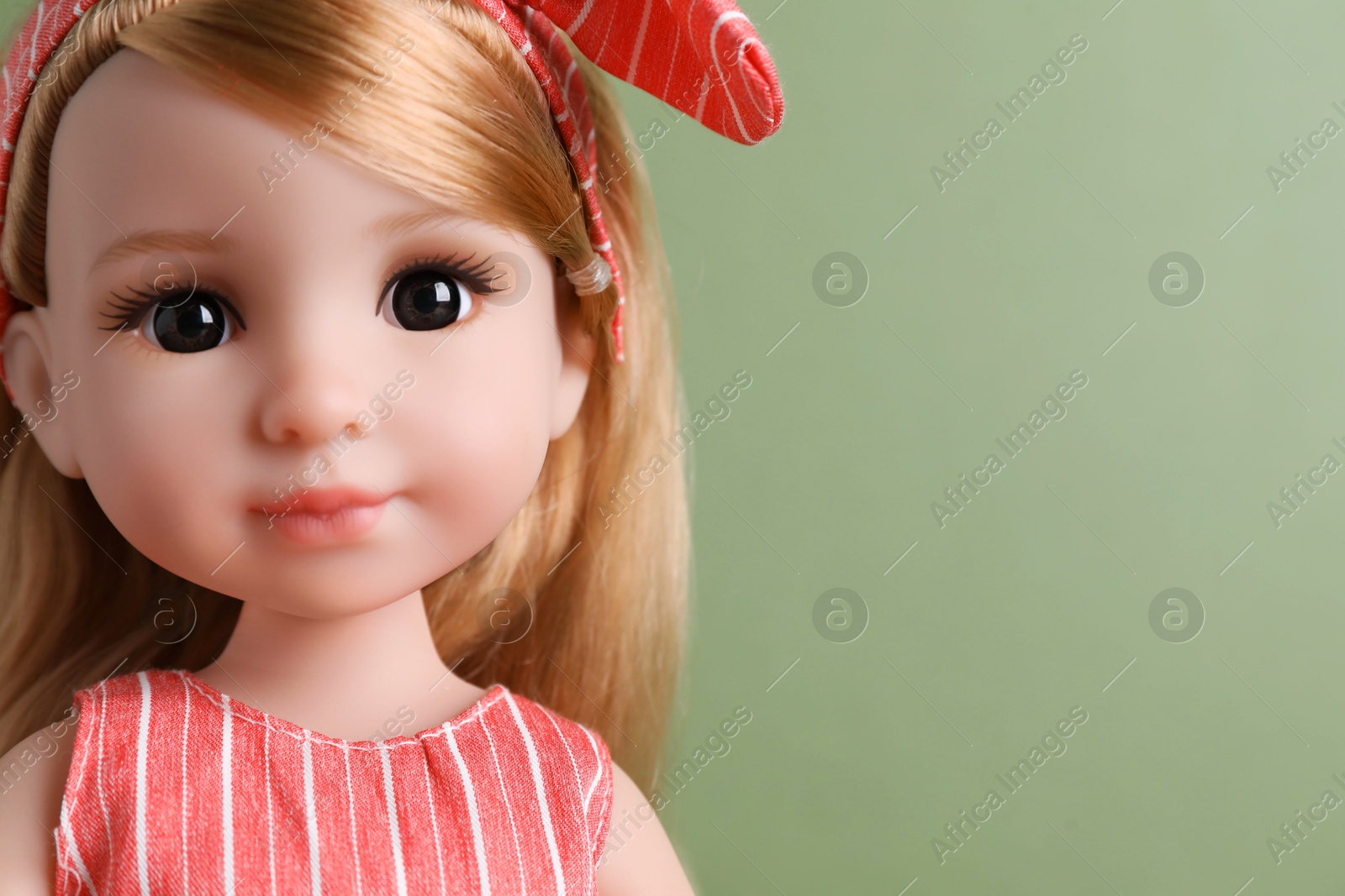 Photo of Beautiful doll with headband on light green background, closeup. Space for text