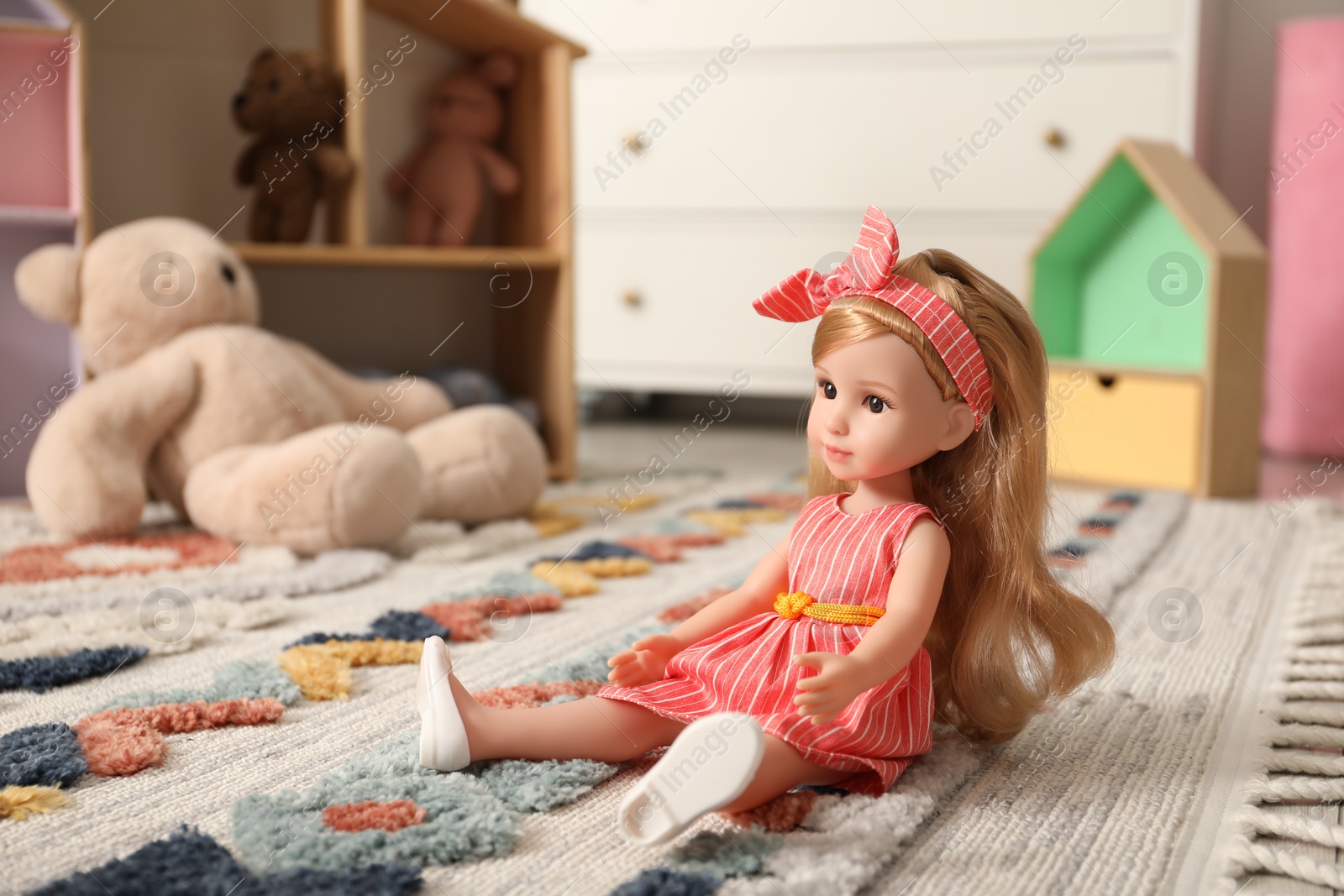 Photo of Beautiful doll and other toys on soft carpet indoors. Space for text