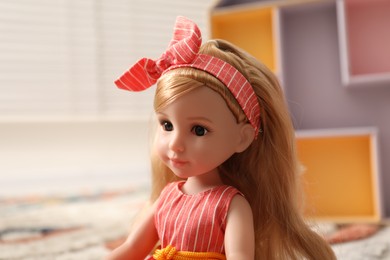 Photo of Beautiful doll in dress and headband indoors, closeup