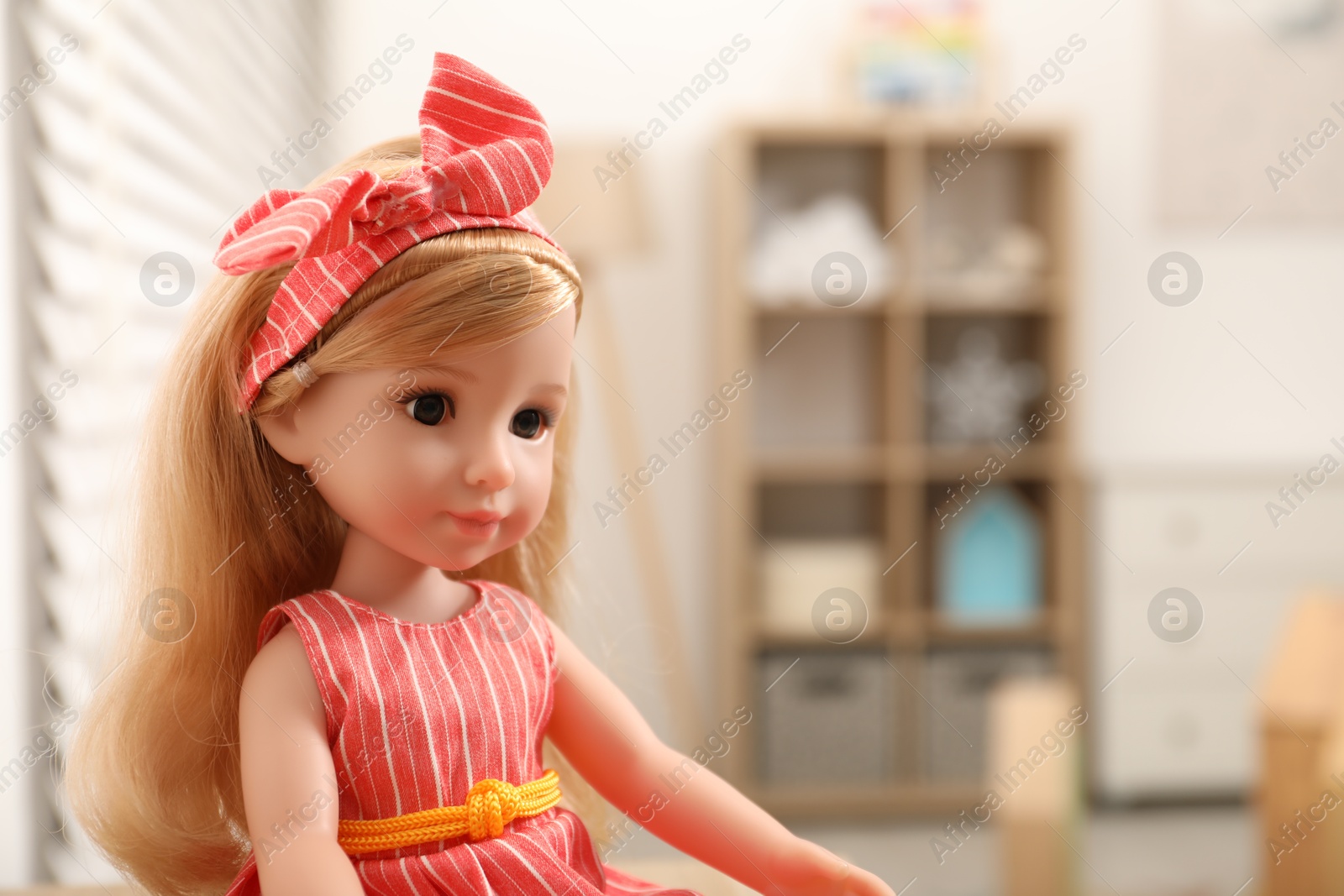 Photo of Beautiful doll in dress and headband indoors, closeup. Space for text