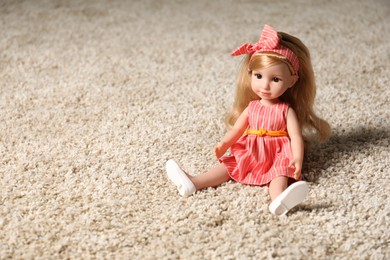 Photo of Beautiful doll in dress and headband on soft carpet. Space for text