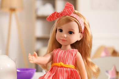 Photo of Beautiful doll in dress and headband indoors, closeup