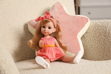 Photo of Beautiful doll and star shaped pillow in armchair indoors