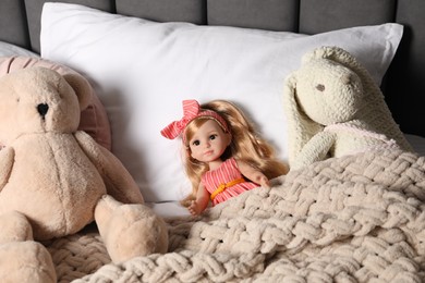 Photo of Beautiful doll, teddy bear and toy bunny in bed